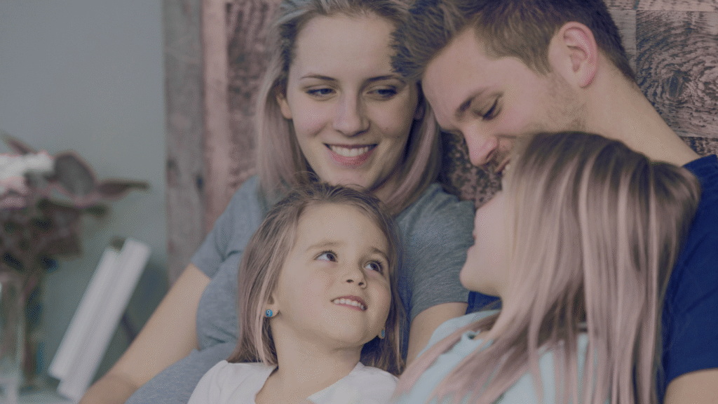 Parents holding kids together on their laps and looking lovingly at them without screens.