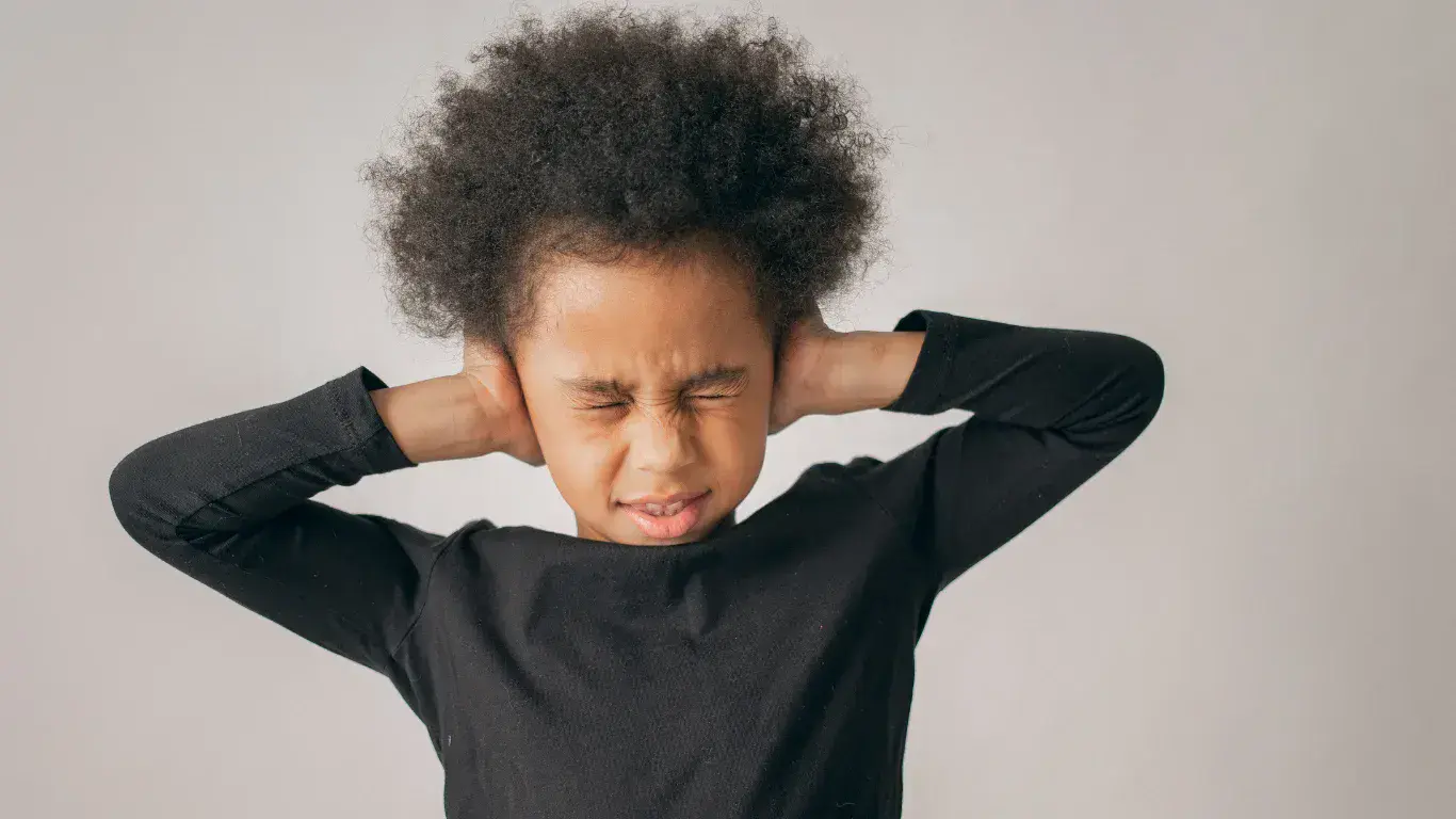 young girl covering her ears due to sensory issues.