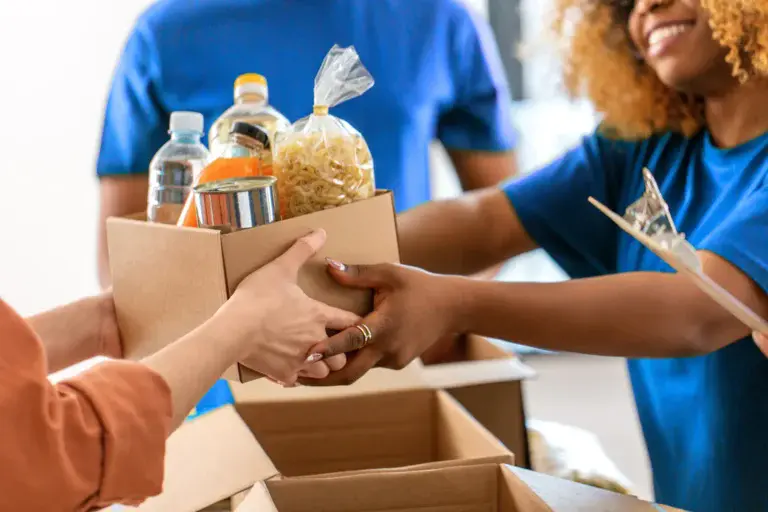 Woman servings during the holidays with family, handing food across a table.